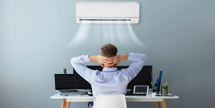 Salarié au bureau avec climatisation pendant une forte chaleur